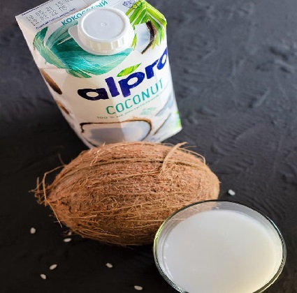 Do you drink coconut milk? Glass of coconut milk with the milk container and a coconut