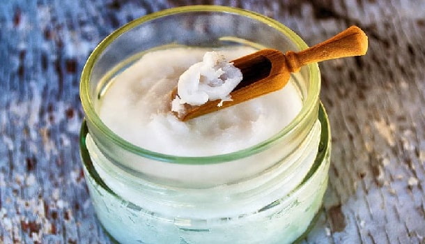 Coconut oil has many uses. Jar of coconut oil with wooden spoon