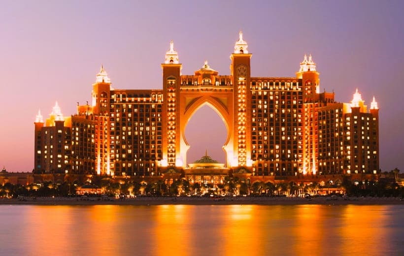 Atlantis the Palm a Nighttime - Dubai Island Premier Hotel. Lights glow in a watery reflection.