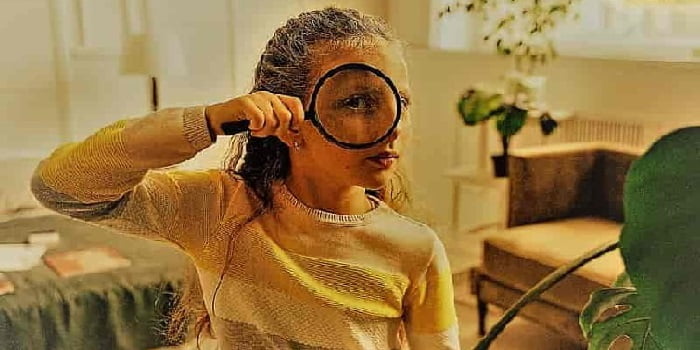Girl looking at plants through a magnifying glass Girl looking at plants through a magnifying glass