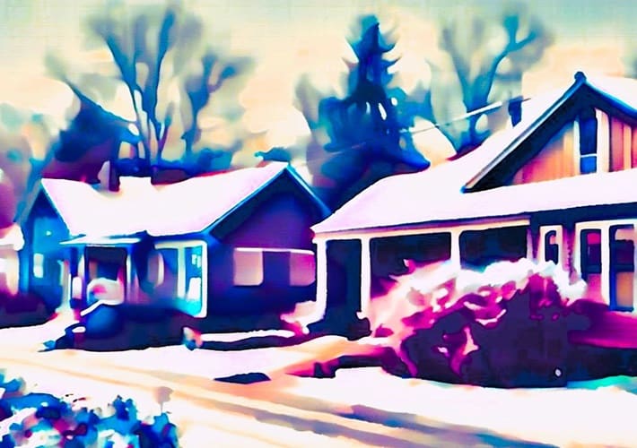 snowed in neighborhood homes along a street in the winter