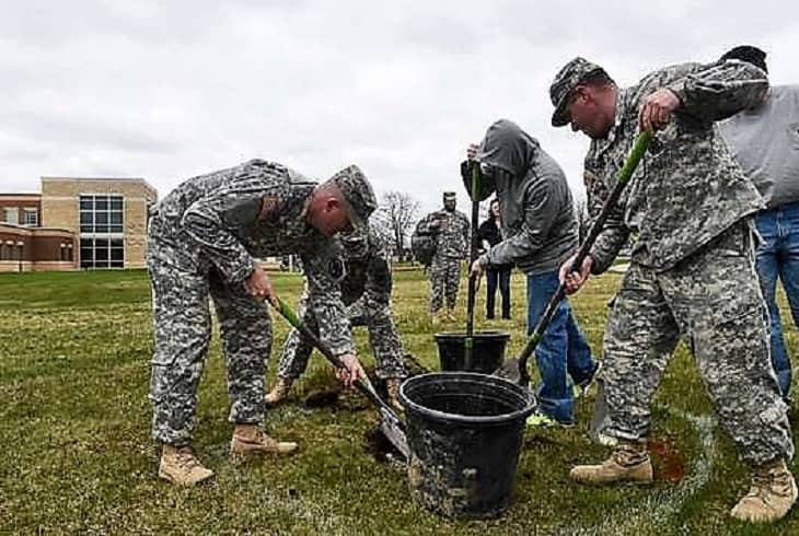 Soldiers digging a hole for planting