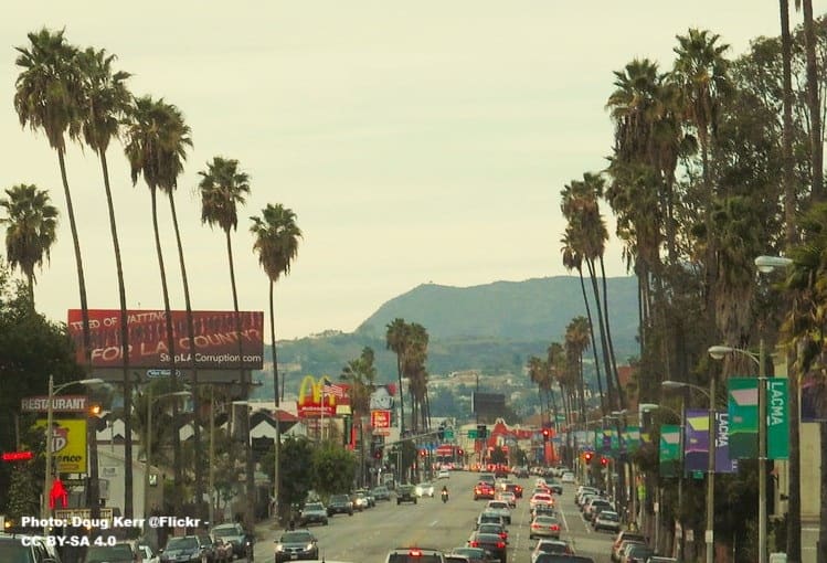 Sunset Boulevard in Los Angeles with traffic and lined with tall palm trees
