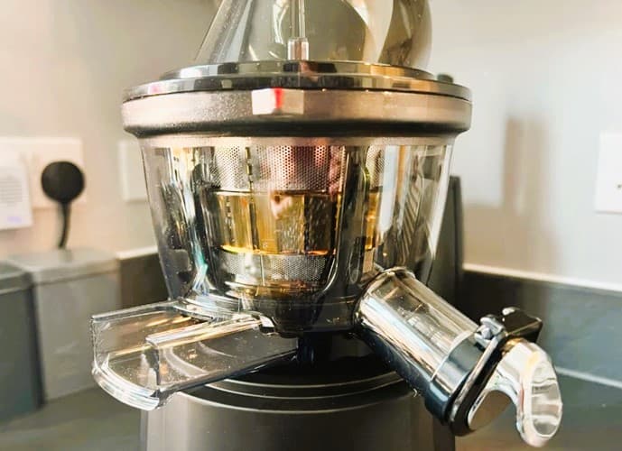 A juicer with two spouts on a counter