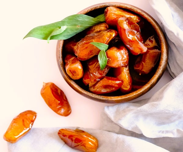 Fruit of the Date palm scattered on a table and in a bowl